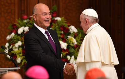 Pope Francis shakes hands with Iraqi President Barham Salih at the Presidential Palace. AFP