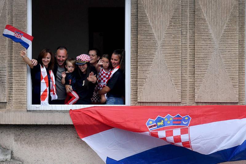 Supporters of Croatia's national football team wave from a window in downtown Zagreb. AFP