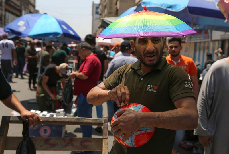 A street vendor wears an umbrella-shaped hat to protect his head from the sun. AFP