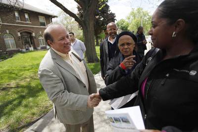 Detroit mayor Mike Duggan, left, greets people in the Boston-Edison neighbourhood who are touring a home being auctioned off. One home will be auctioned off per day with an opening bid of US$1,000. Joshua Lott / Reuters