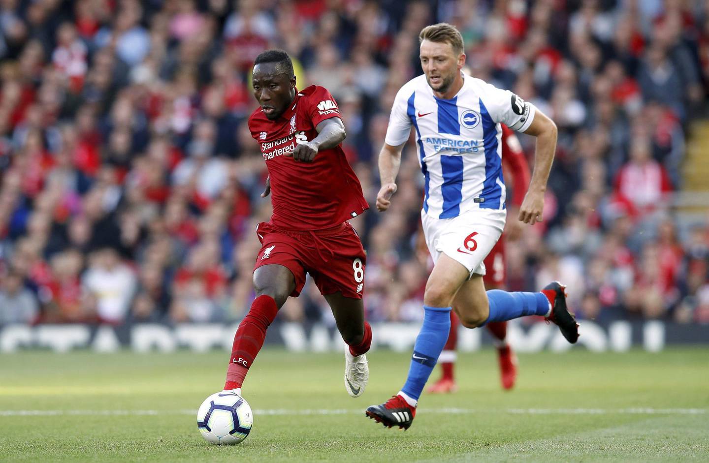 Liverpool's Naby Keita, left and Brighton's Dale Stephens vie for the ball, during the English Premier League soccer match between Liverpool and Brighton,  at Anfield, in Liverpool, England, Saturday, Aug. 25, 2018. (Martin Rickett/PA via AP)