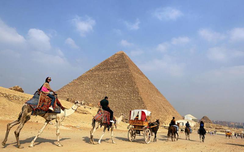 Tourists ride past the Giza pyramids on camels and in horse carts on the outskirts of Cairo. Mohamed Abd El Ghany / Reuters