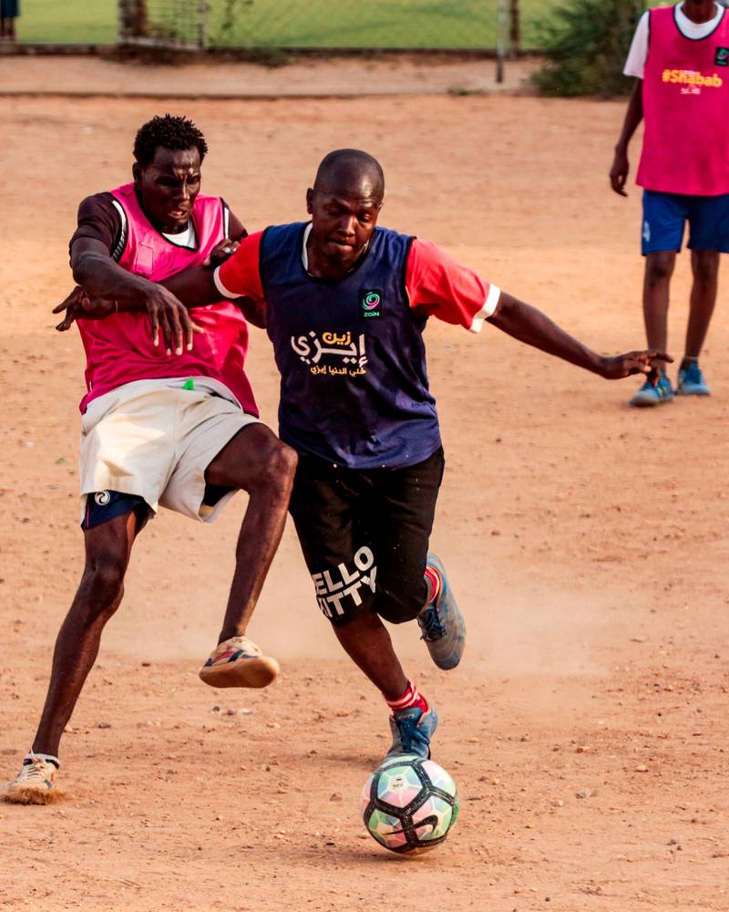 Sudanese youths play football on a dirt field in the capital Khartoum.