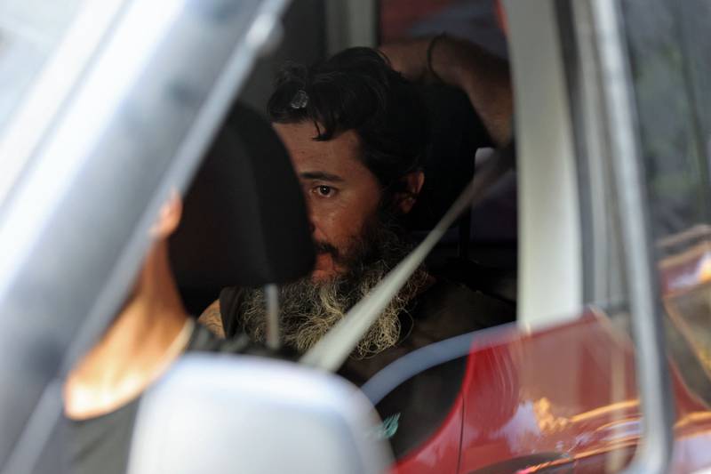Bassam Hussein in a police car in Beirut. He turned himself in after taking staff hostage for several hours in a bank branch in Lebanon's capital. AFP