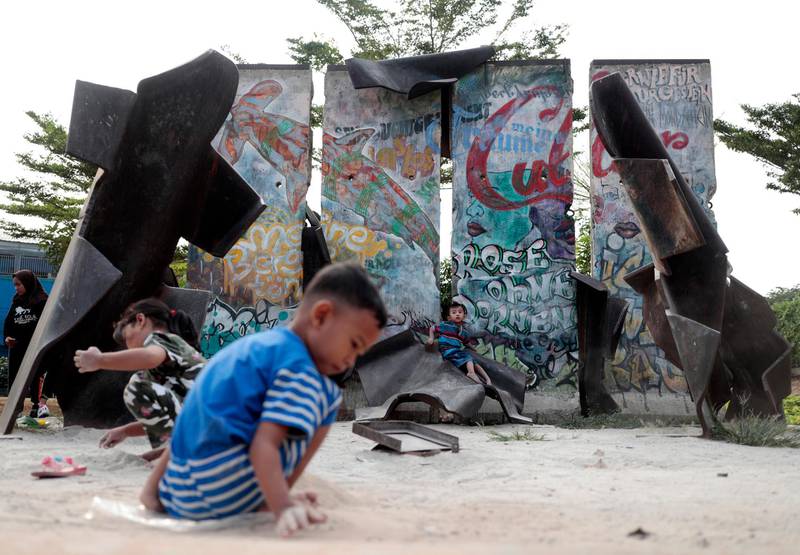 Indonesian children play near pieces of Berlin Wall erected as parts of an installation art by Indonesian artist Teguh Ostenrik, at Kalijodo Park in Jakarta, Indonesia. AP Photo