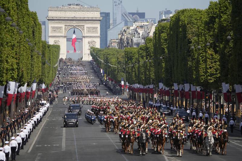 Troops march down the Champs-Elysees. AP 