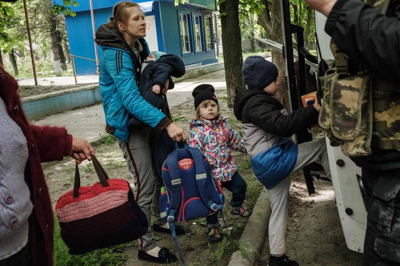 Nazar, right, boards a bulletproof bus to evacuate with his family from the eastern Ukraine city of Lyman. AFP