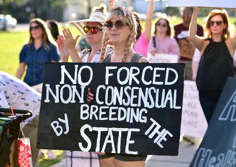 Emily Milford holds her protest sign during a  rally in front of the Duval County Courthouse in Jacksonville, Florida.  The Florida Times-Union / AP