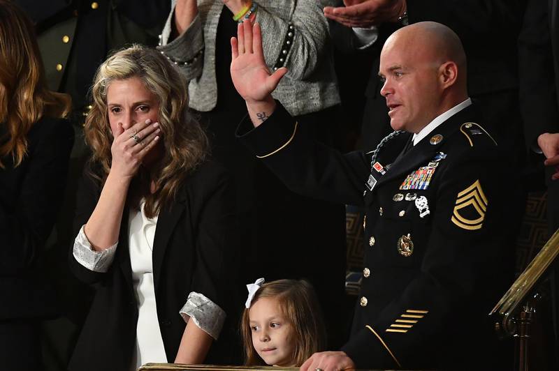 Sgt Townsend Williams (right) waves alongside his daughter and his wife Amy (left) after returning from deployment in Afghanistan on during the State of the Union address at the US Capitol in Washington, DC.  AFP