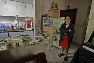 A Lebanese woman stands next to her empty refrigerator in her apartment in Zouk Mosbeh, north of Beirut. AFP