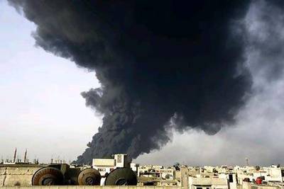 Smoke rises from a refinery in Homs, Syria, a flashpoint between rebels and the government, after being hit by an explosion. AFP / HO / SANA