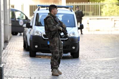 An armed French soldier stands near the site where a car slammed into soldiers on patrol in Levallois-Perret. Stephane De Sakutin.