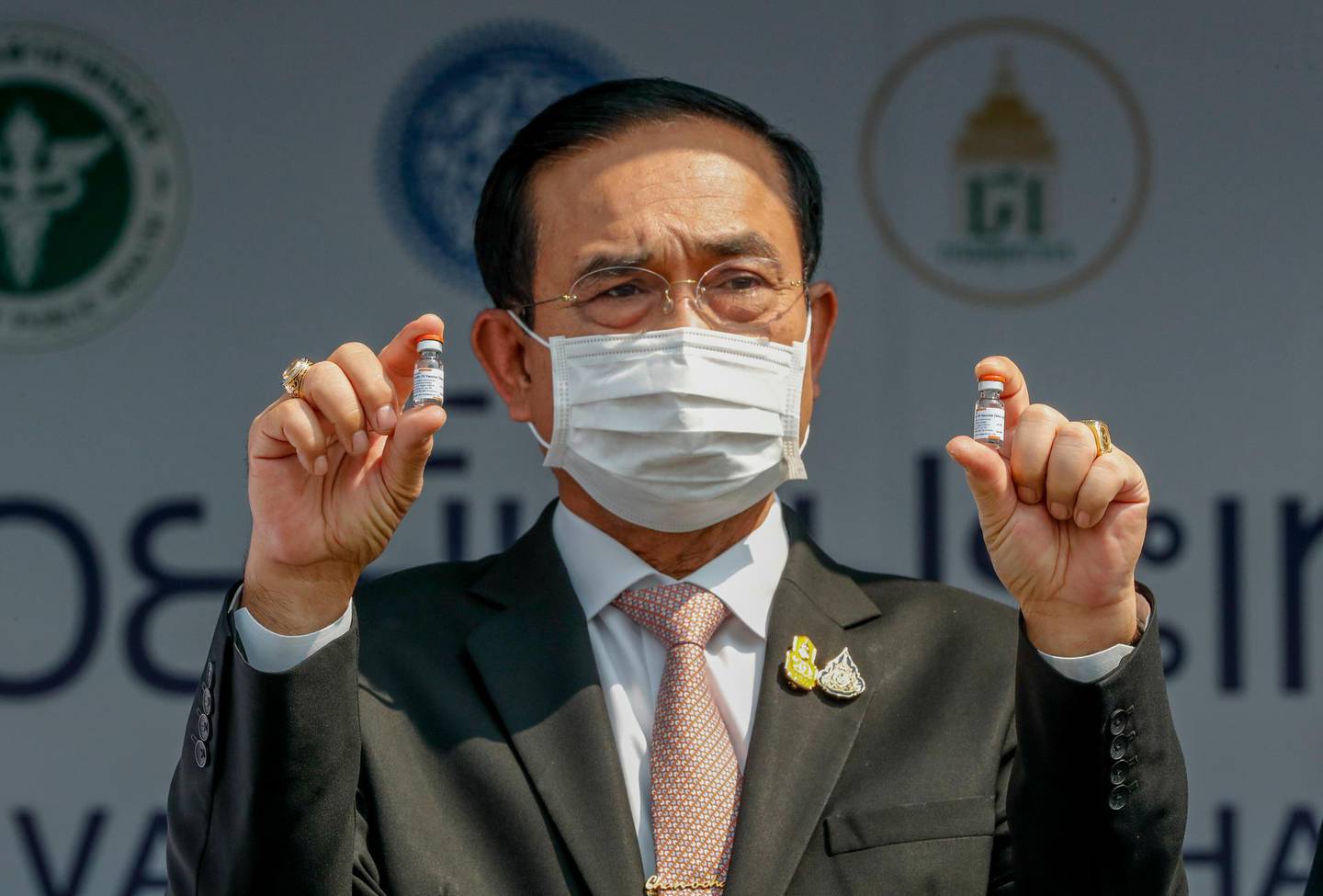 FILE - In this Feb. 24, 2021, file photo, Prime Minister Prayuth Chan-ocha holds samples of the Sinovac vaccine during a ceremony to mark the arrival of 200,000 doses in a shipment at the Suvarnabhumi airport in Bangkok. Prayuth on Wednesday, June 16, 2021, declared that the country is planning to fully reopen to foreign visitors without restrictions by mid-October, as the government seeks to restart the crucial tourist industry, heavily hit by the coronavirus pandemic. (AP Photo/Sakchai Lalit, File)