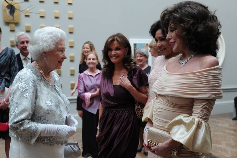Queen Elizabeth speaks to actresses Joan Collins and Kate O'Mara and singer Shirley Bassey. Getty