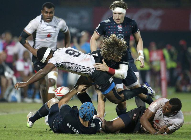 Fiji’s Jasa Veremalua, right, and Emosi Mulevoro, centre, fight for the ball against England’s Richard de Carpentier, left, and Dan Bibby, centre-right, during their Cup Final match. Karim Sahib / AFP