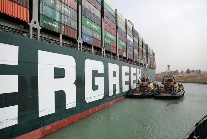 A handout picture released by the Suez Canal Authority on March 25, 2021 shows Egyptian tug boats trying to free Taiwan-owned MV Ever Given (Evergreen), a 400-metre- (1,300-foot-)long and 59-metre wide vessel, lodged sideways and impeding all traffic across the waterway of Egypt's Suez Canal. Egypt's Suez Canal Authority said it was "temporarily suspending navigation" until refloating of the MV Ever Given ship was completed on one of the busiest maritime trade routes. / AFP / Suez CANAL / - / == RESTRICTED TO EDITORIAL USE - MANDATORY CREDIT "AFP PHOTO / HO / Suez Canal" - NO MARKETING NO ADVERTISING CAMPAIGNS - DISTRIBUTED AS A SERVICE TO CLIENTS ==
