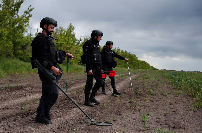 Members of Ukraine's State of Emergency Service inspect an area for mines and unexploded shells. Reuters 