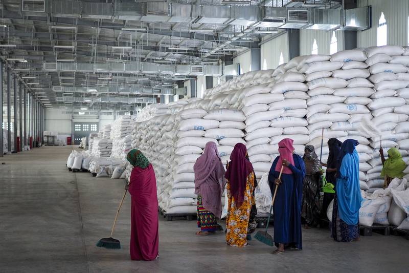 Workers clean the floor as sacks of food earmarked for the Tigray and Afar regions sit in piles in a warehouse of the World Food Programme in Semera, the regional capital for the Afar region in Ethiopia. AP