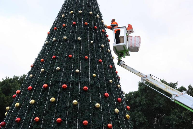 A municipality worker decorates the Christmas tree in Manger Square. AFP