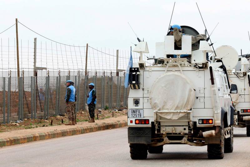 A picture taken on December 26, 2018, from the southern Lebanese village of Kfar Kila, shows United Nations Interim Forces in Lebanon (UNIFIL) patrolling the border fence with Israel.  / AFP / Mahmoud ZAYYAT
