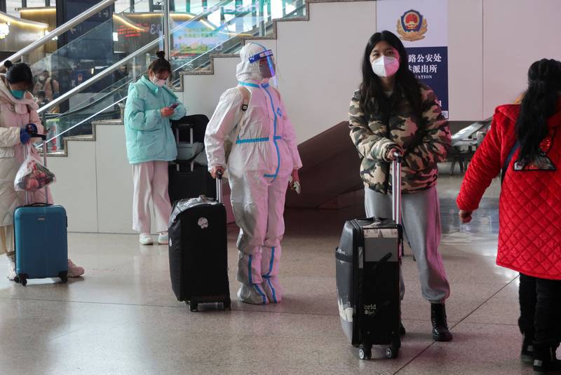 A person wearing a protective suit waits at a waiting hall of a railway station, after the government eased curbs on the coronavirus disease control, in Wuhan, China December 11, 2022. Reuters
