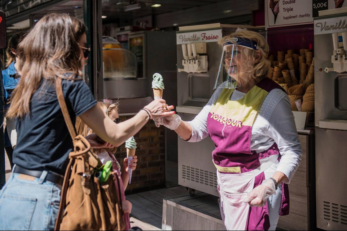 epa08428580 An ice cream seller wears a protective mask works during the first week end after two months of strict lockdown in Paris, France, 17 May 2020. France began a gradual easing of its lockdown measures and restrictions amid the COVID-19 pandemic.  EPA/Julien de Rosa