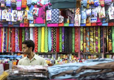A man arranges fabric at a store in Satwa in Duba. many such stores are family run businesses that have been passed down generations. Francois Nel/Getty