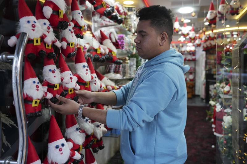 A Palestinian youth looks at Santa Claus dolls at a shop in Gaza city. AP