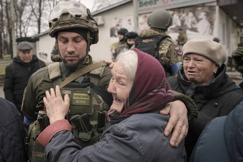 A woman hugs a Ukrainian soldier after a convoy of military and aid vehicles arrived in the formerly Russian-occupied town of Bucha, near Kyiv. AP