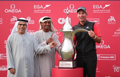 Lucas Herbert is presented with the Omega Dubai Desert Classic trophy.  EPA