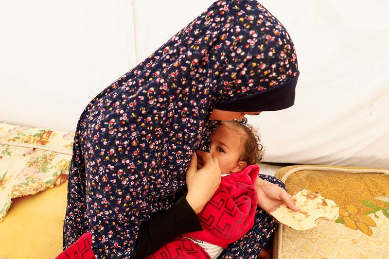 A displaced Palestinian woman holds her child as they shelter in a tent at Nasser hospital in Khan Younis in the southern Gaza Strip on November 19, 2023. Reuters. 