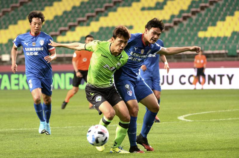 Jeonbuk Hyundai Motors FC's Han Kyo-won, left, fights for the ball against Suwon Samsung Bluewings's Park Dae-won. AP
